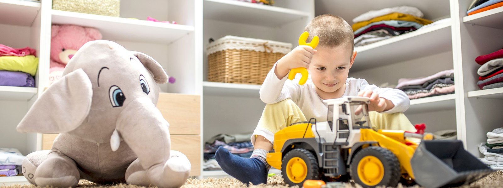 adorable-little-boy-playing-with-toys-while-sitting-floor-his-playroom